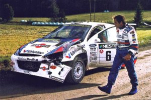 Карлос Сайнц осматривает повреждения своей машины на ралли WRC 2000 года